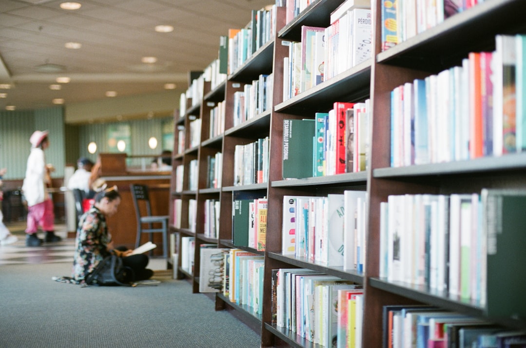 woman-reading-book-in-front-of-bookshelves-7yavepdv6is