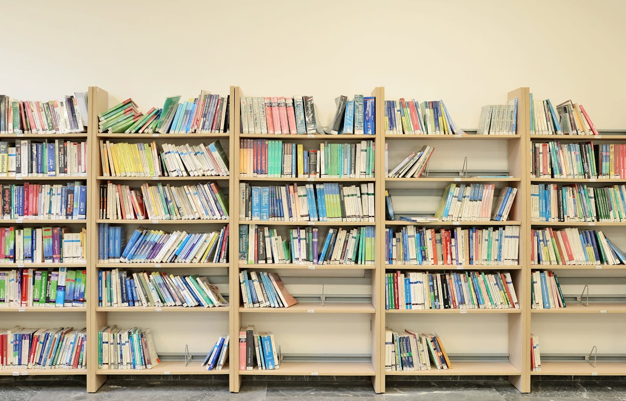 Well-organized bookshelf filled with colorful academic books in a library.
