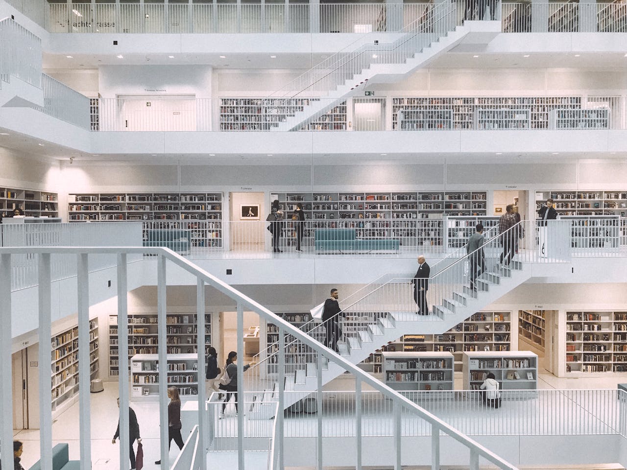 Spacious and minimalist design of the Stuttgart City Library showcasing multiple levels of books and people.